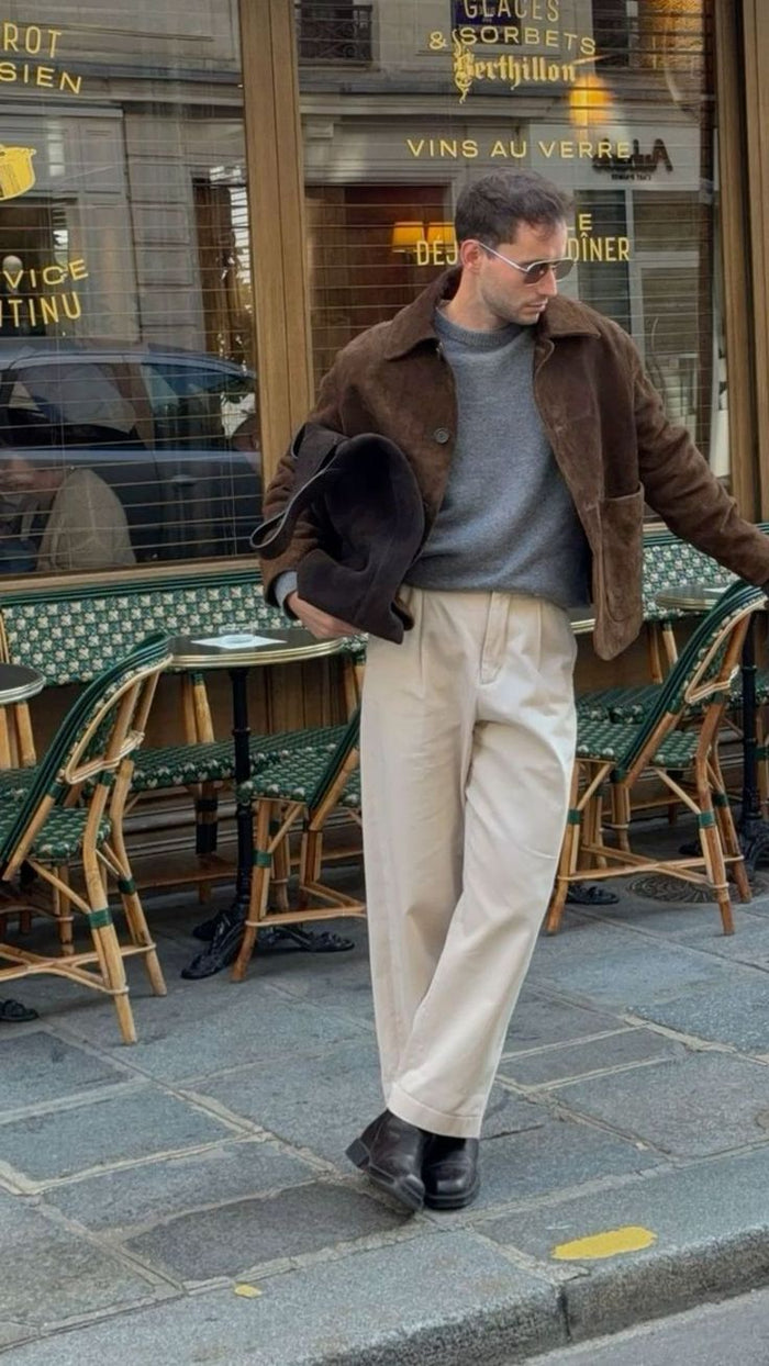 Homme en veste bleu marine et pantalon beige marchant en ville