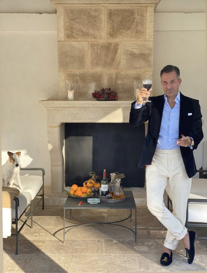 Homme en veste bleu marine et pantalon blanc dans un intérieur