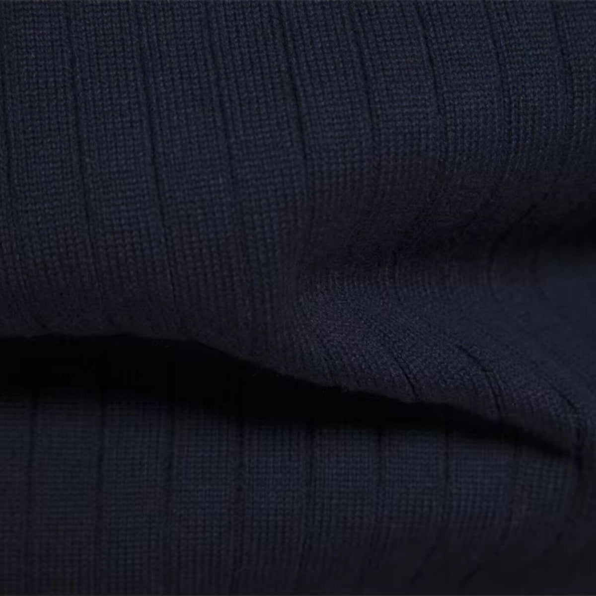 Détail de la maille côtelée et du bord-côte du pull bleu marine