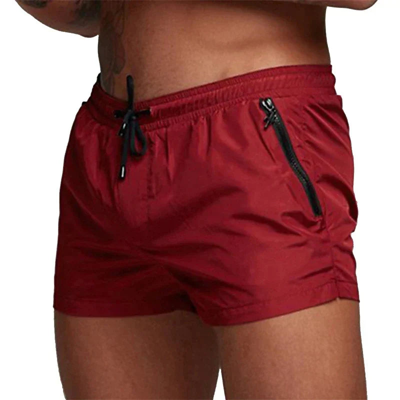 Gros plan du short de bain rouge homme, cordon noir et poche zippée latérale