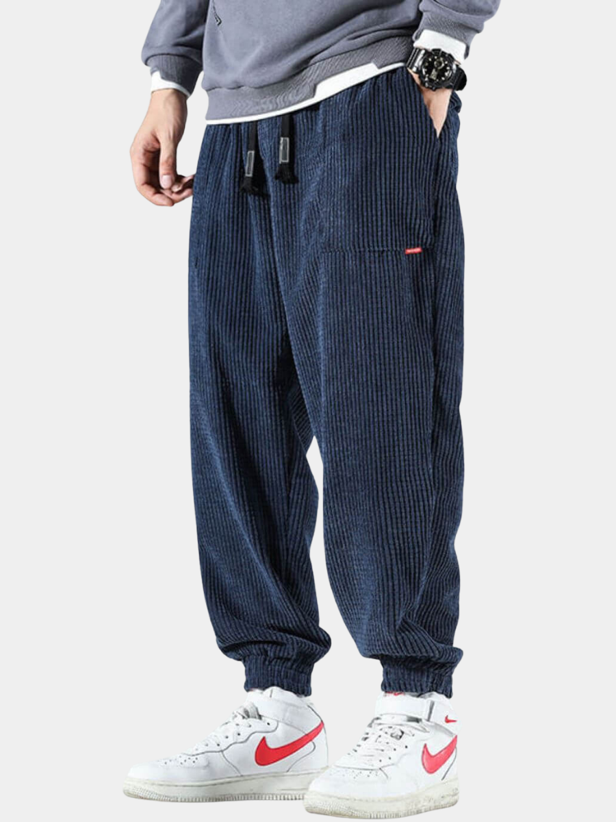 Pantalon de jogging en velours côtelé bleu marine porté avec un sweat et des baskets – Assas