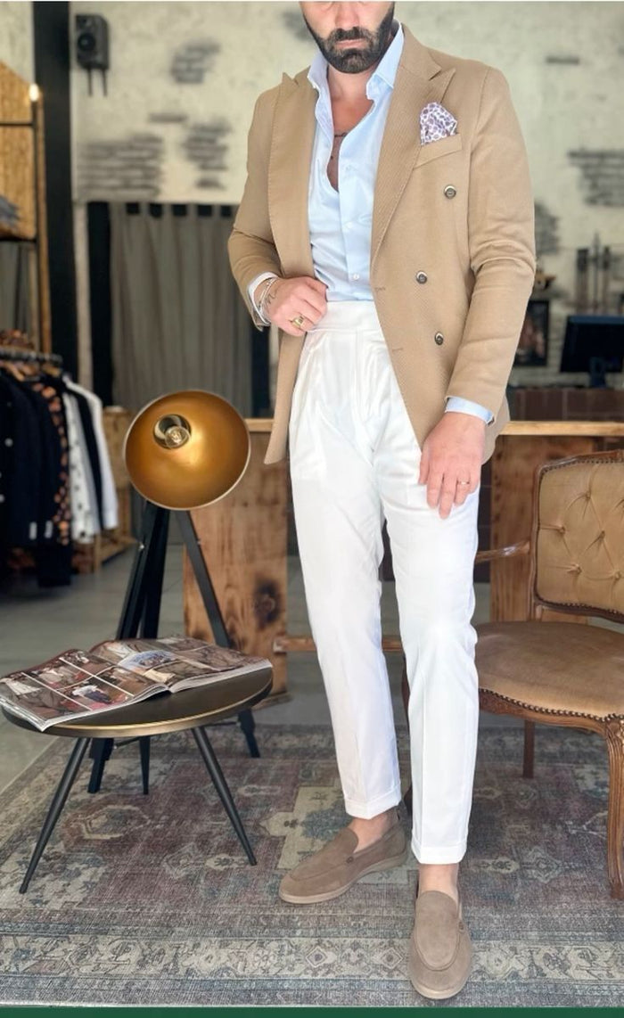 Homme en veste beige et pantalon clair dans une rue